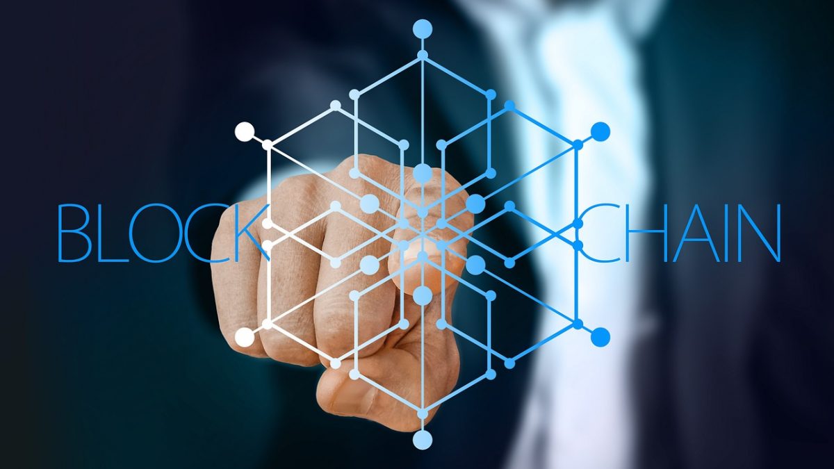 A man touching the centre of an image representing blockchain technology