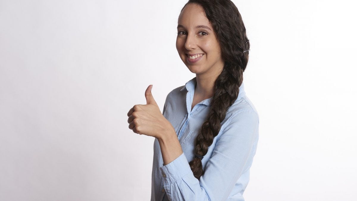A happy woman posing with her thumbs up