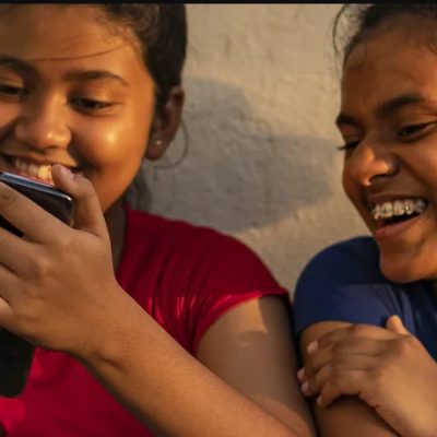 Jugalbandi - Young girls peeping into mobile phone
