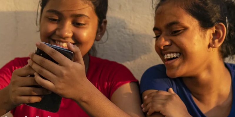 Jugalbandi - Young girls peeping into mobile phone